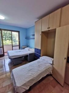2 camas en una habitación con paredes azules en Bellagio Panoramic Mini Loft Giove, en Bellagio