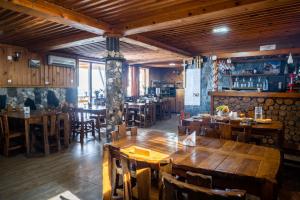 een restaurant met een grote houten tafel en stoelen bij Guesthouse Ushguli Maspindzeli in Ushguli