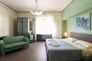a bedroom with a green bed and a green chair at Parioli Suites Apartment in Rome
