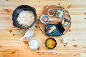 drewniany stół z talerzem jedzenia z ryżem w obiekcie Mitsuse base camp - Vacation STAY 52579v w mieście Saga