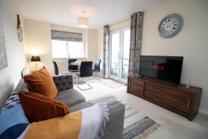 a living room with a couch and a flat screen tv at Upper Millennium by Tŷ SA - Free Parking in Newport