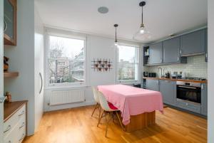 a kitchen with a table with a pink table cloth at GuestReady - Family-Friendly Flat in Battersea in London