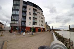 a building next to a body of water at Upper Millennium by Tŷ SA - Free Parking in Newport