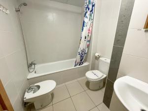 een witte badkamer met een toilet en een wastafel bij Apartamentos Playa de Benicarló 3000 in Benicarló
