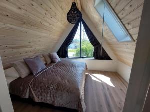 a bed in a room with a large window at Nieuw vakantiehuis Domburg, in centrum dichtbij strand in Domburg