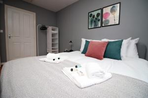 - une chambre avec un lit blanc et des serviettes dans l'établissement Usk Way by Tŷ SA, à Newport