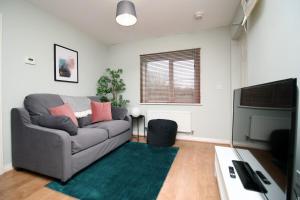 a living room with a couch and a flat screen tv at Usk Way by Tŷ SA in Newport