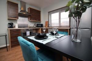 a kitchen with a table with a vase of flowers at Usk Way by Tŷ SA in Newport