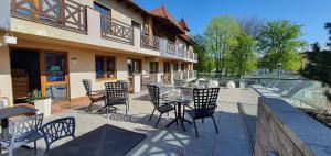a patio with chairs and tables and a building at Dom Gościnny Złota Rybka in Dziwnów