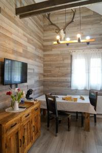 Kata - Lak في بايلي توشناد: غرفة طعام بجدران خشبية وطاولة مع كراسي