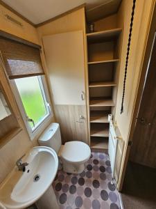 uma pequena casa de banho com WC e lavatório em 3 Bed Holiday Home, Doniford Bay em Watchet