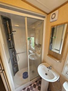 uma casa de banho com um chuveiro e um lavatório. em 3 Bed Holiday Home, Doniford Bay em Watchet