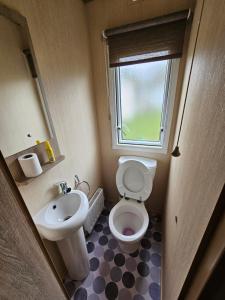 uma pequena casa de banho com WC e lavatório em 3 Bed Holiday Home, Doniford Bay em Watchet
