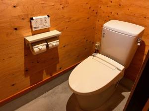 a bathroom with a toilet in a wooden wall at Makino Kogen 123 Building / Vacation STAY 79154 in Kaizu