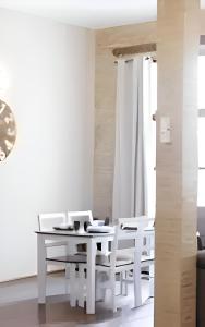 a white dining room with a white table and chairs at Serranos Flat by Concept Flats in Valencia