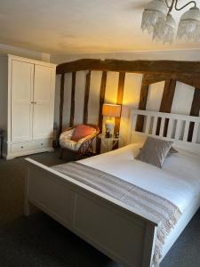 um quarto com uma cama grande e uma cadeira em The Kentford em Kentford