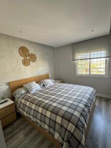 a bedroom with a large bed with a plaid blanket at Ático in Málaga