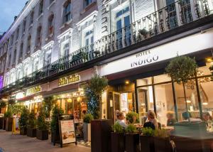 personnes assises à l'extérieur d'un restaurant dans une rue de la ville dans l'établissement Hotel Indigo London Hyde Park Paddington, an IHG Hotel, à Londres