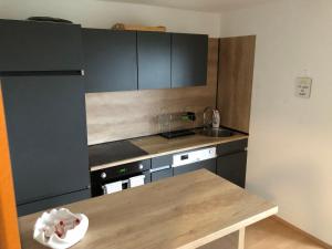 a kitchen with black cabinets and a wooden table at Sweet Hideout Filovci in Filovci