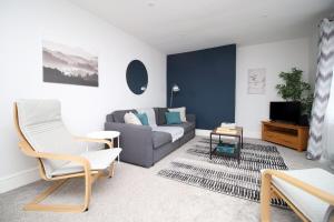 a living room with a couch and a tv at Willow Way by Tŷ SA in Nantgarw