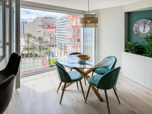 a dining room with a glass table and chairs at El Séptimo Cielo de la Bahía de los Naranjos - Primera Línea de Playa in Cullera
