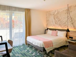 Rúm í herbergi á Nonanteneuf appart hōtel Sierre - contactless check-in