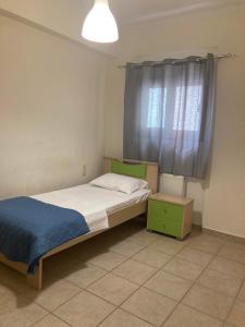 um pequeno quarto com uma cama e uma janela em Όμορφο διαμέρισμα με εκπληκτική θέα em Menídion