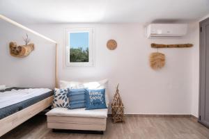 a bedroom with a bed and a chair and a window at Bonzoe #5 in Parikia