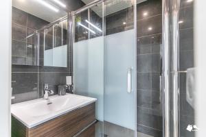 La salle de bains est pourvue d'un lavabo et d'une douche. dans l'établissement MBA Levallois Splendide Appart - Proche Paris, à Levallois-Perret