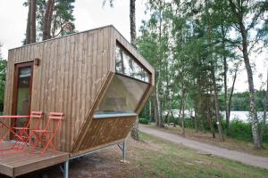 a tiny house on a trailer with two red chairs at Sleep Space 3 - Salemer See in Salem