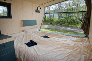 Una cama en una habitación pequeña con dos bolsas azules. en Sleep Space 4 - Salemer See, en Salem