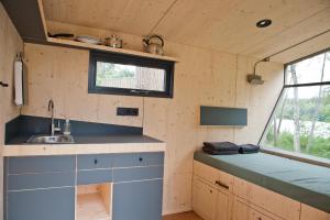 una cocina en una casa pequeña con fregadero y ventana en Sleep Space 4 - Salemer See, en Salem
