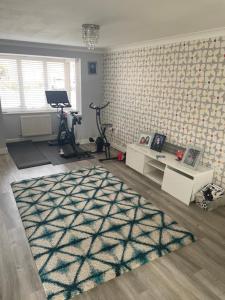 a living room with a gym with exercise bikes and a rug at North East Escape in Holystone