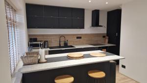 a kitchen with black cabinets and a counter top at Designed Gem in Cayton