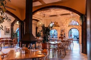 un restaurante con mesas, sillas y lámparas de araña en Hotel Castillo de Monda, en Monda
