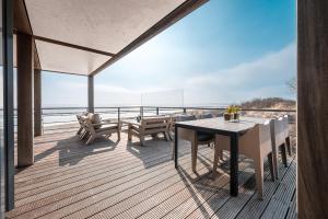 アウウドルプにあるLuxury Beach Villa 6p - 10m van het Grevelingenmeer - Villa 17の海を望むデッキ(テーブル、椅子付)