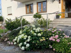 un jardín de flores frente a una casa en Bergchalet Mirabell - Hofgut, en Friedrichshafen