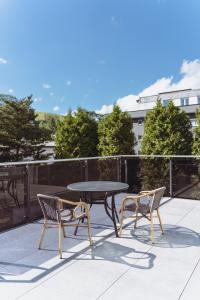 d'une table, de deux chaises et d'une table sur un balcon. dans l'établissement Apartamenty przy Głównym Deptaku, à Wisła