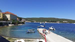 a group of people standing on a dock with boats in the water at Apartman Sara-Vis in Vis
