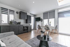 ein Wohnzimmer mit Sofa und Tisch in der Unterkunft MBA Levallois Splendide Appart - Proche Paris in Levallois-Perret