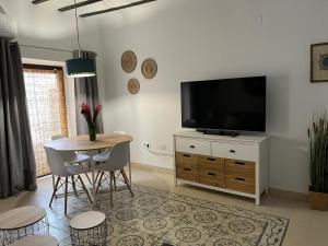 un soggiorno con televisore, tavolo e sedie di MINAS CENTRO a Úbeda