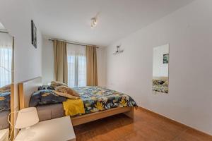 een kleine slaapkamer met een bed en een spiegel bij Ocean view Agua Marina 1 bedr apartment in San Miguel de Abona