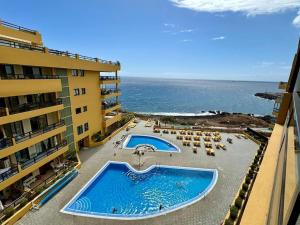 een uitzicht op een hotel met een zwembad en de oceaan bij Ocean view Agua Marina 1 bedr apartment in San Miguel de Abona