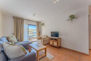 een woonkamer met een bank en een tv bij Ocean view Agua Marina 1 bedr apartment in San Miguel de Abona