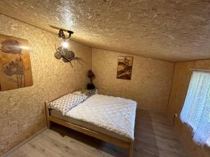małe łóżko w pokoju z sufitem w obiekcie Pod Dębem w Białowieży