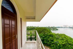 uma porta para uma varanda com vista para a água em Hotel Mahal em kolkata