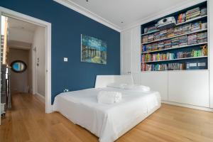 a bedroom with a white bed and a blue wall at GuestReady - Family Stay in the heart of Fulham in London