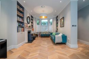 a living room with a blue couch and a fireplace at GuestReady - Family Stay in the heart of Fulham in London