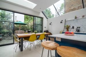 a kitchen with a table and some yellow chairs at GuestReady - Family Stay in the heart of Fulham in London