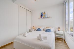a white bedroom with a white bed and a window at GREEN AGAVE by Welcome Tenerife in Playa de las Americas